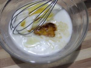 Vanilla extract and oil added to yogurt-sugar mixture